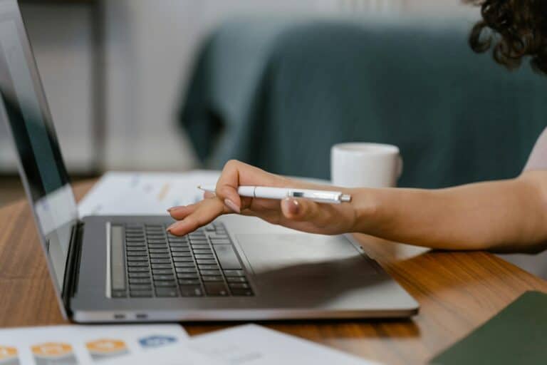 Person pointing to laptop screen while planning ADA compliance upgrades for a business