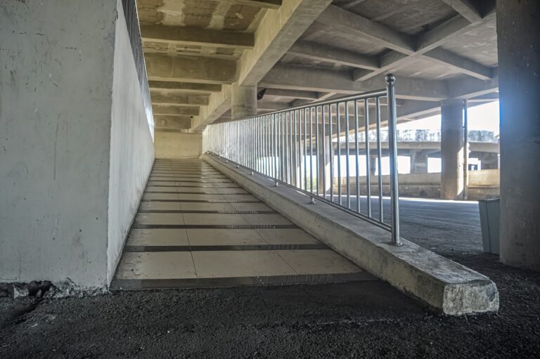 7 ADA Ramp Requirements Every California Property Owner Must Know 3 Indoor concrete ramp with railing showing steep incline and insufficient landing space