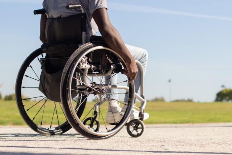 black man wheelchair riding along park road 1