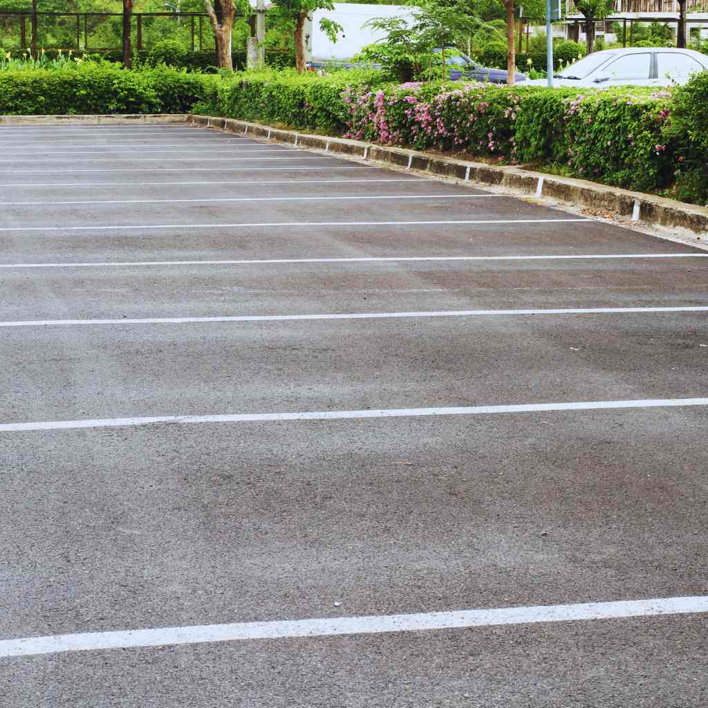 Fresno CASp Inspections | Lower ADA Lawsuit Risk With Proactive Compliance 2 reshly striped parking lot with clear stall lines and landscaped borders — illustrating the importance of ADA-compliant parking layout and maintenance verified through CASp inspections in Fresno.