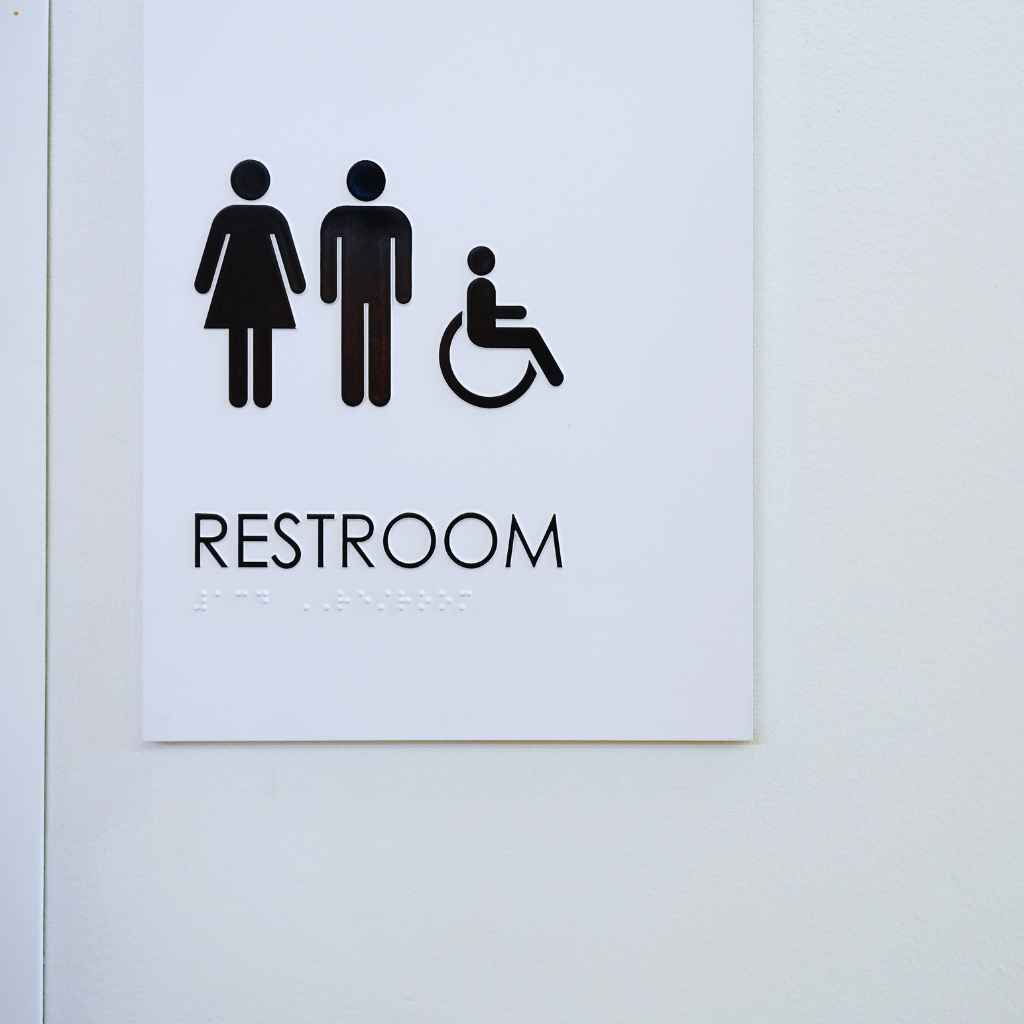 Fresno CASp Inspections | Lower ADA Lawsuit Risk With Proactive Compliance 1 DA-compliant restroom sign showing male, female, and wheelchair-accessible symbols — representing proactive accessibility measures and compliance inspections in Fresno, California.