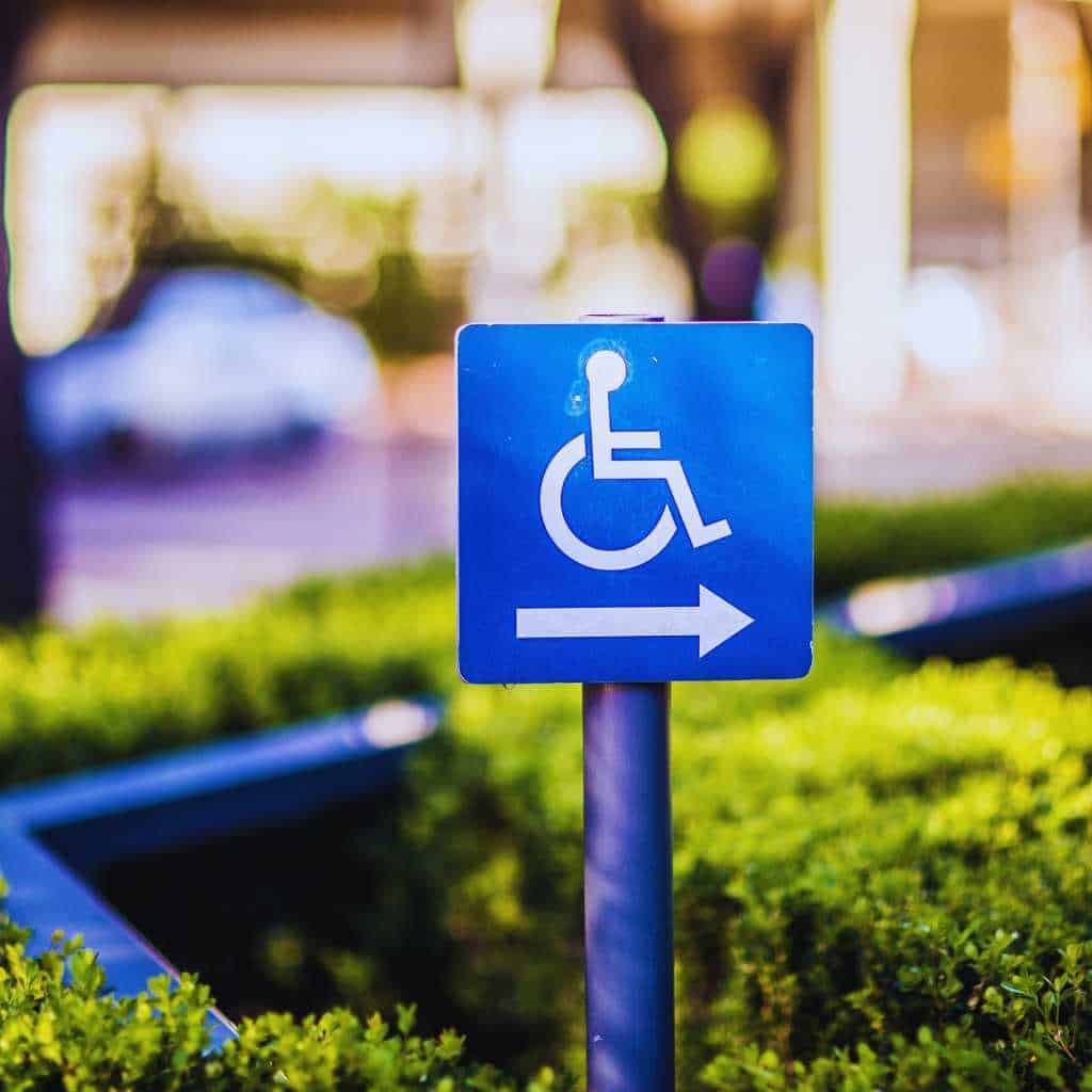 Blue wheelchair accessible sign with white arrow indicating accessible path in Fresno commercial area