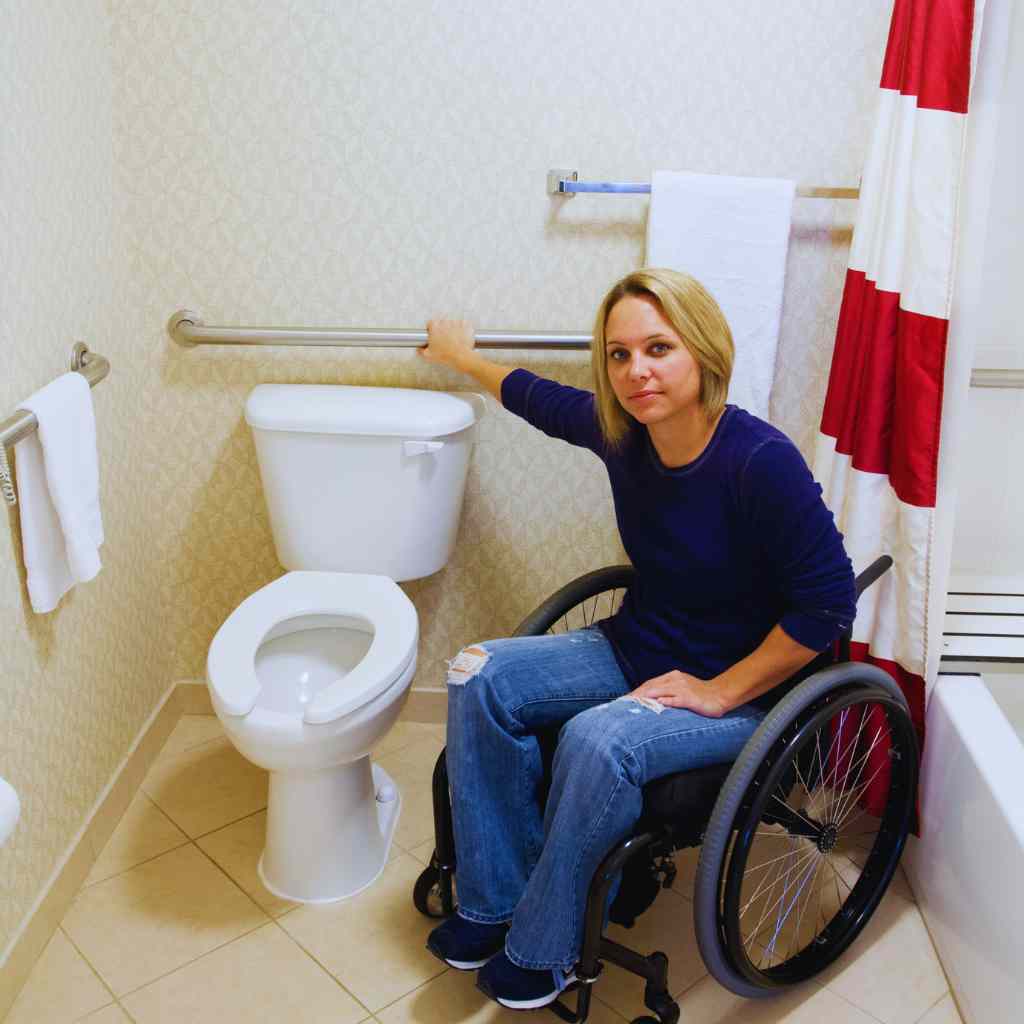 Wheelchair User Demonstrating Accessible Toilet Transfer and Grab Bar Placement